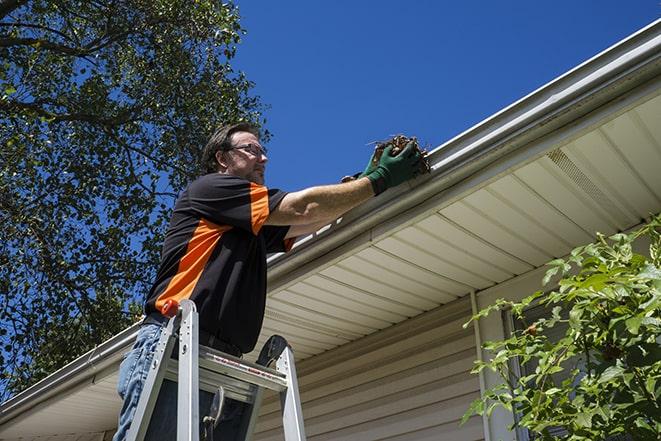 a maintenance worker fixing a leaking gutter in Arcadia